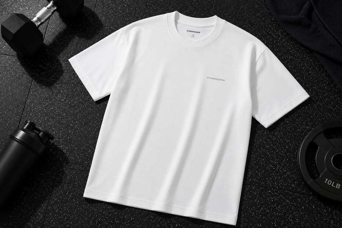 White athletic shirt on a gym floor with weights, showcasing premium antibacterial t-shirts.