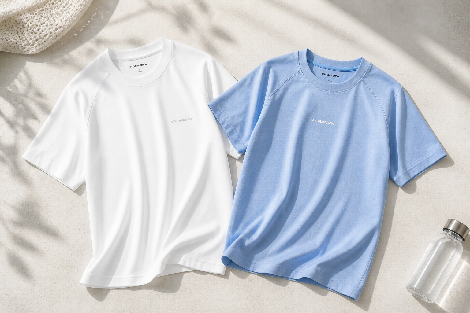 Flat lay of white and blue T-shirts showcasing fabric, knit, and fit to explain what makes a T-shirt breathable.